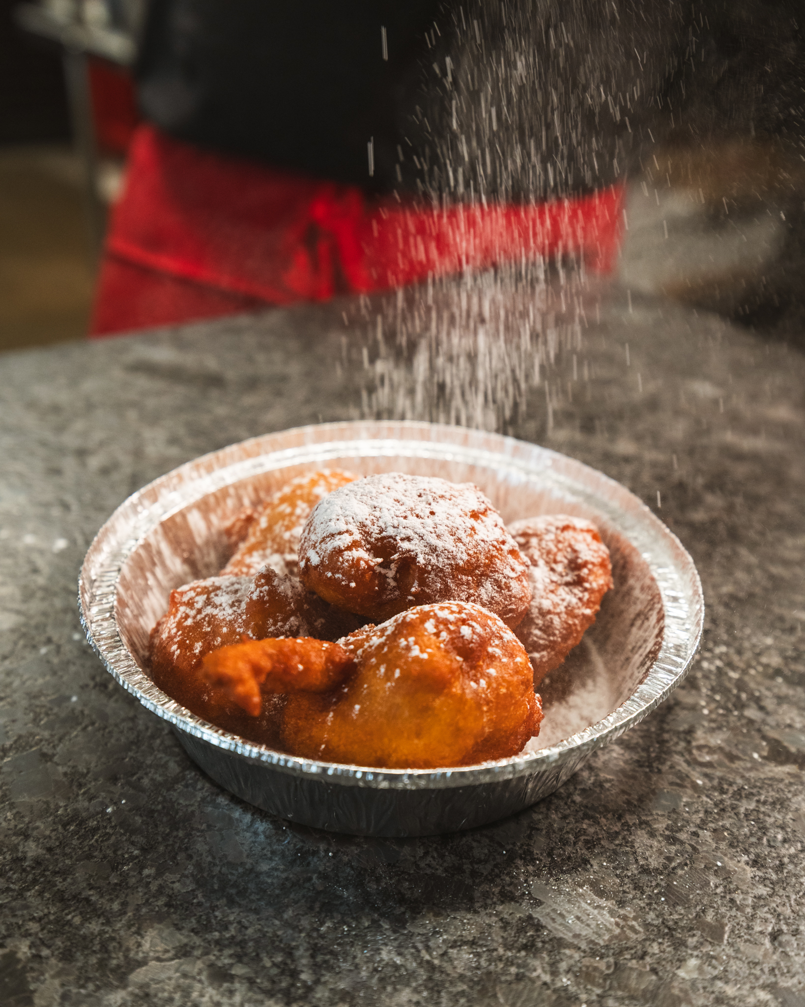 Powdered sugar falling onto freshly fried dough in the Jackson Square kitchen