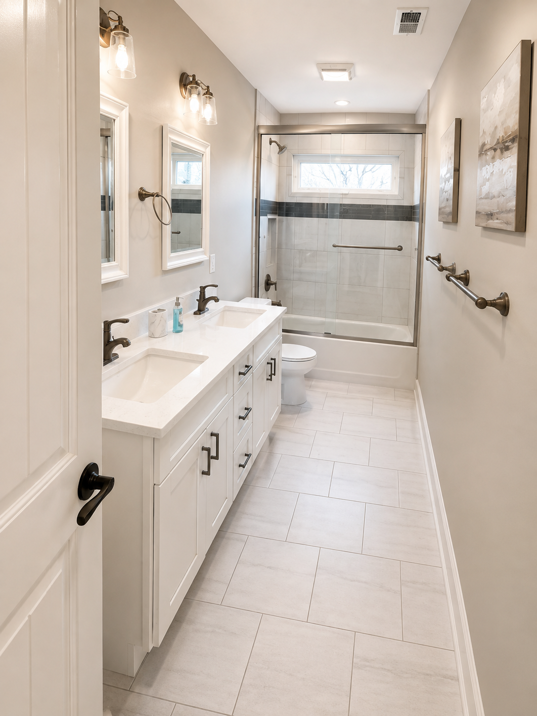 Renovated bathroom with a white vanity, tiled floor and glass shower enclosure
