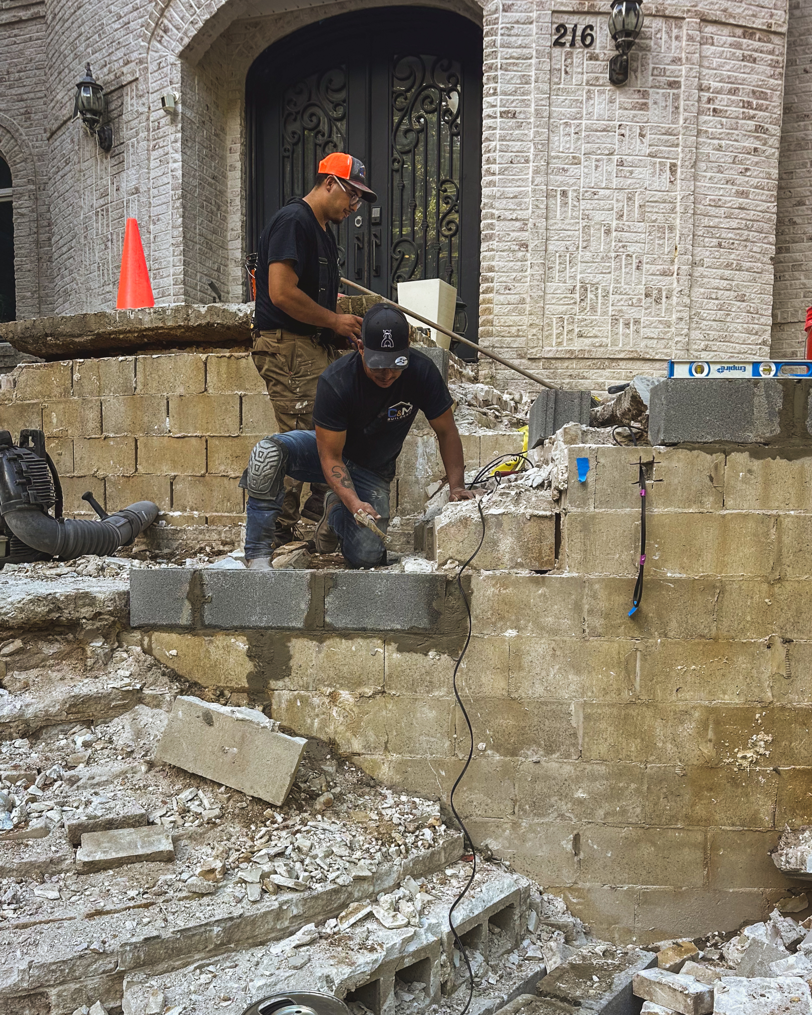 C&M crew cutting and fitting masonry on front steps, photographed by Mattioli Media
